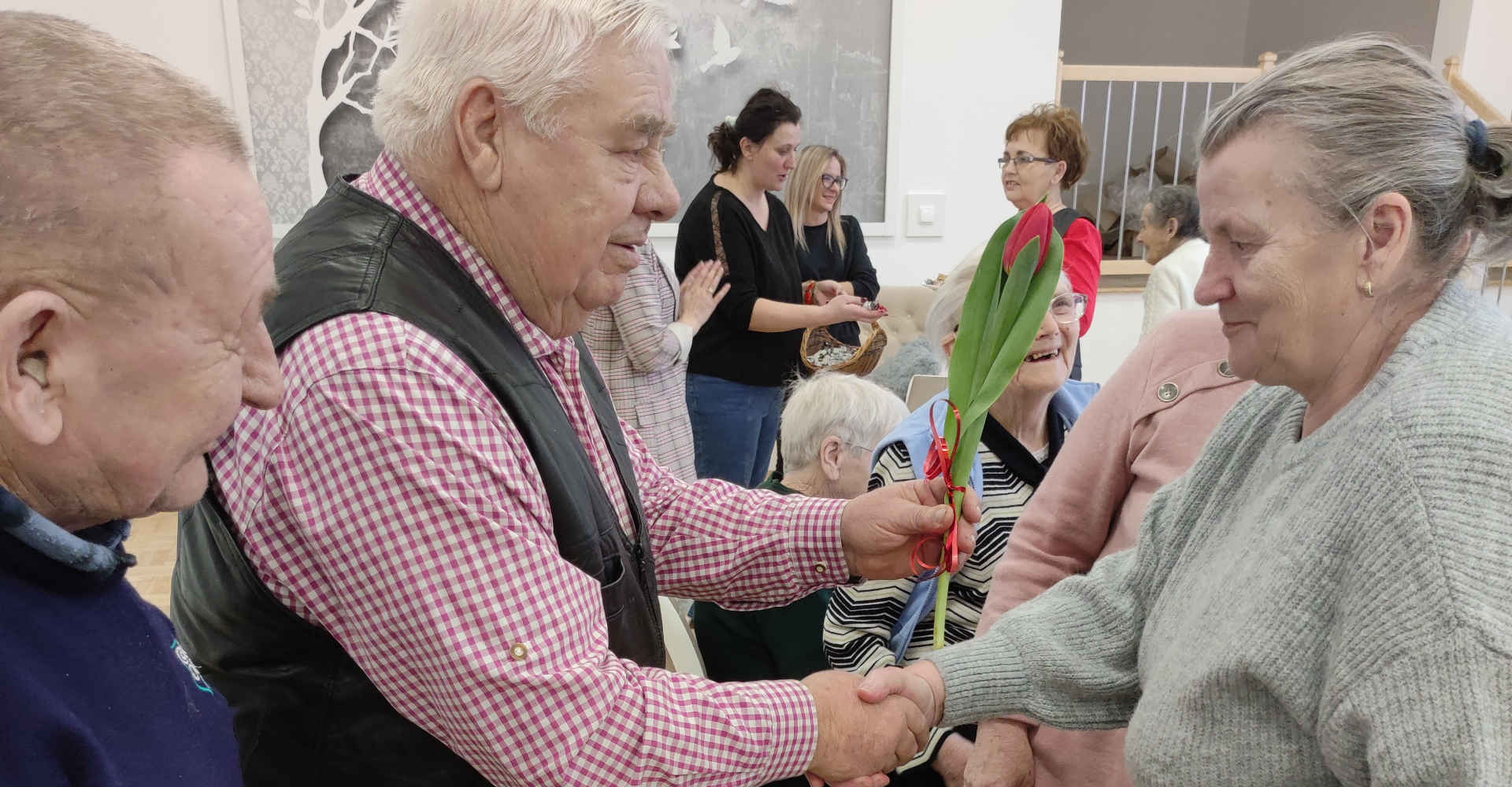 Mężczyzna daje kwiatka kobiecie z okazji Dnia Kobiet