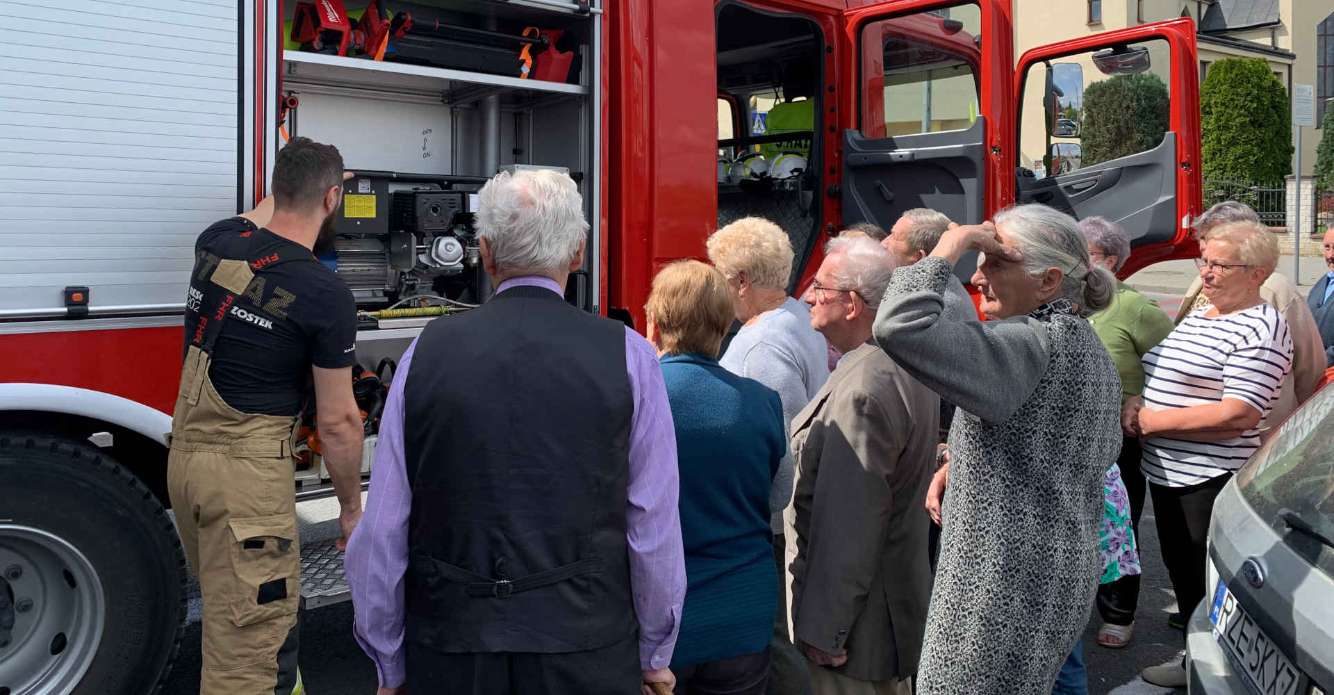 Seniorzy oglądają wóz strażacki