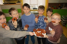Sześciu chłopców je ciastka oponki