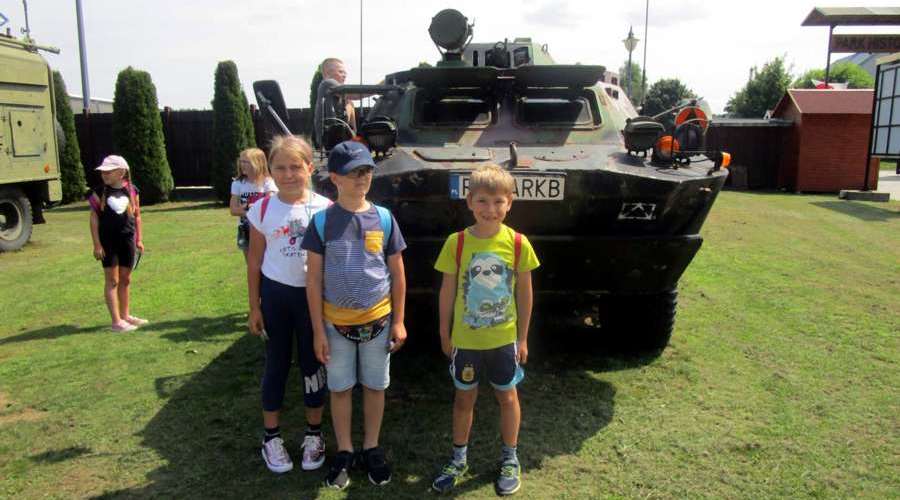 Dzieci na tle wozu wojskowego